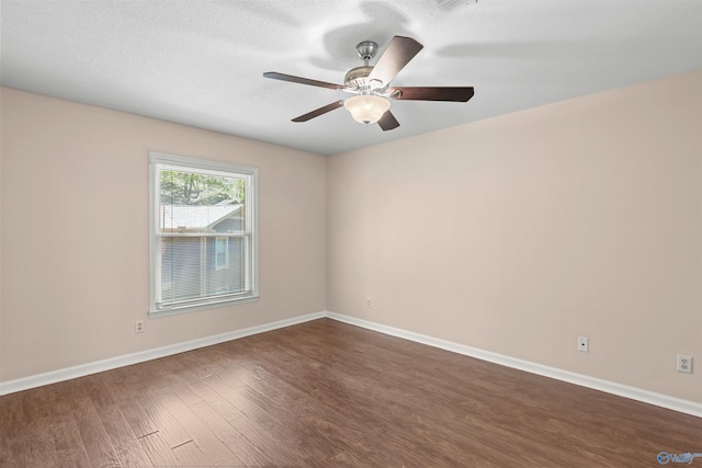 unfurnished room featuring baseboards, a ceiling fan, and dark wood-style floors