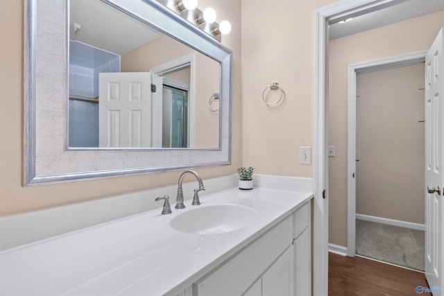 bathroom featuring baseboards, vanity, and wood finished floors