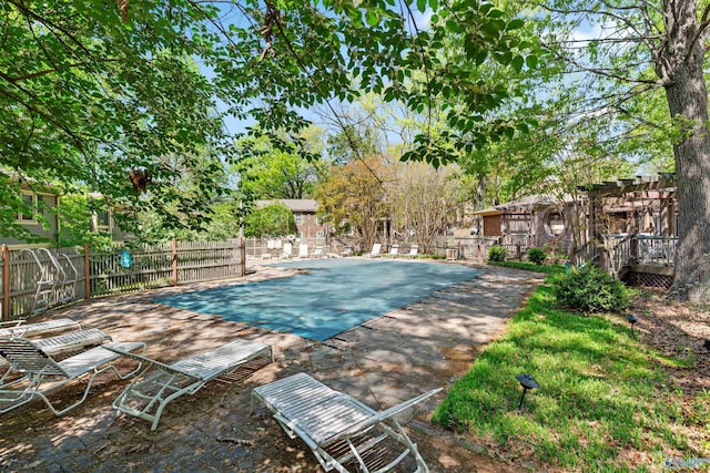 view of swimming pool with a pergola and fence
