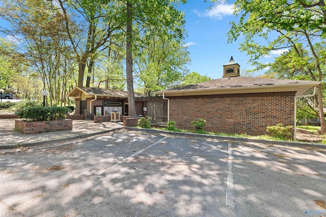 view of front of home featuring brick siding and uncovered parking