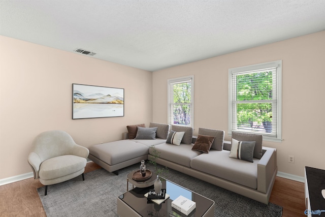 living area with visible vents, baseboards, and wood finished floors