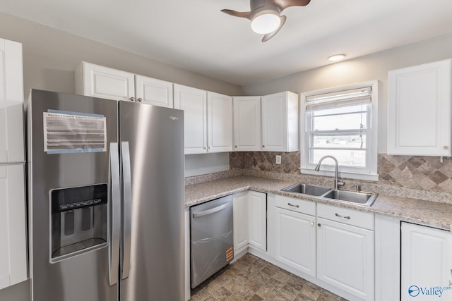 kitchen featuring a sink, stainless steel appliances, tasteful backsplash, and white cabinetry