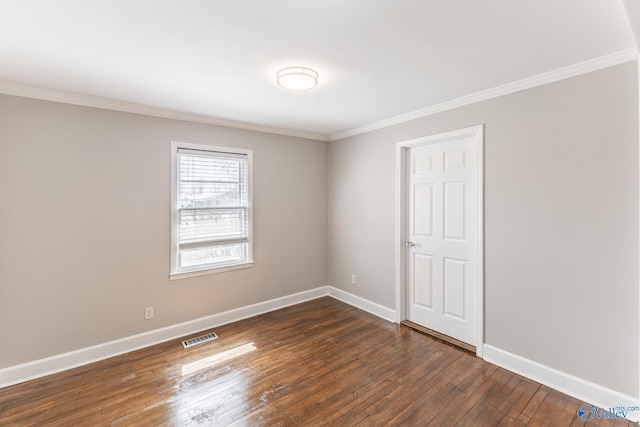 empty room with visible vents, baseboards, dark wood-style floors, and crown molding