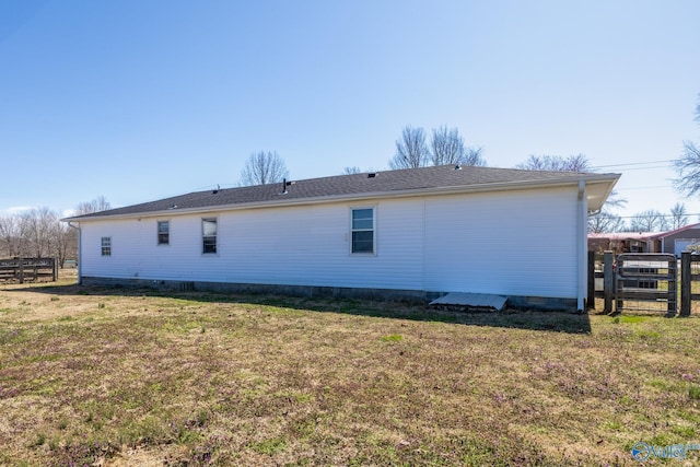 back of house with crawl space, a lawn, and fence