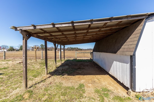 view of yard featuring an attached carport and a rural view