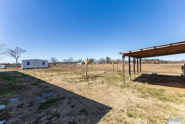 view of yard with a carport, a rural view, and fence