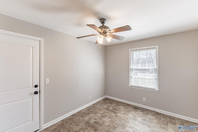 empty room with visible vents, baseboards, and ceiling fan