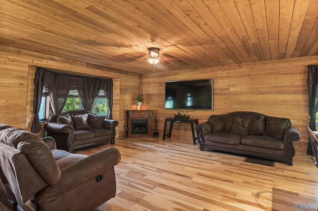 living room with wood ceiling, ceiling fan, wooden walls, and light wood-type flooring