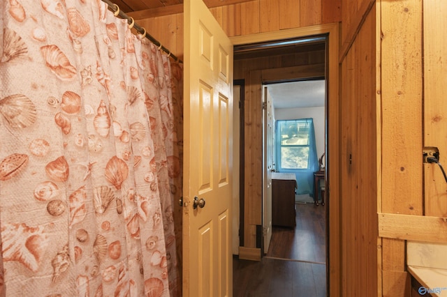 hall featuring hardwood / wood-style flooring and wooden walls