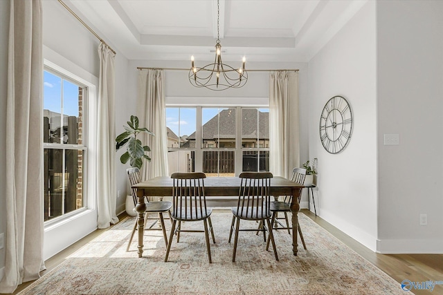 dining room with beamed ceiling, a wealth of natural light, a notable chandelier, and light wood-type flooring