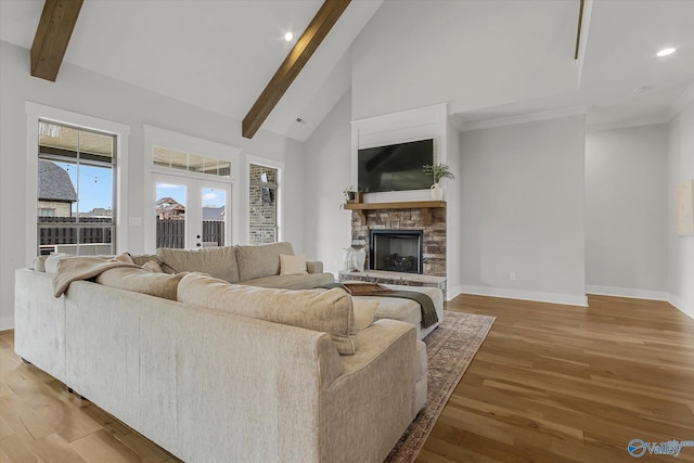 living room with french doors, a stone fireplace, wood-type flooring, high vaulted ceiling, and beam ceiling