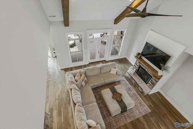 living room featuring wood-type flooring and vaulted ceiling with beams