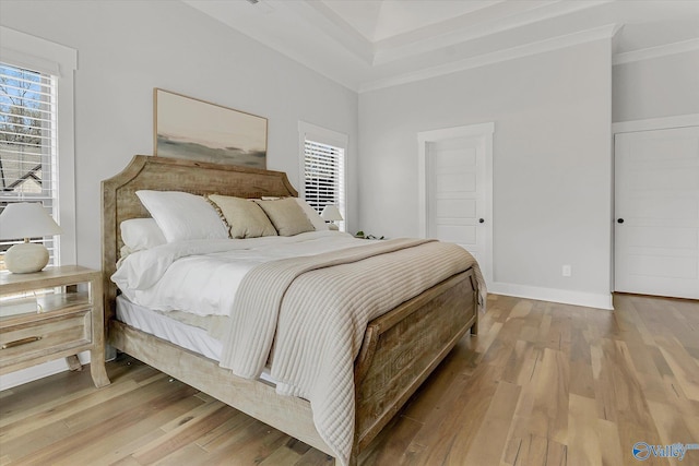 bedroom with ornamental molding and light wood-type flooring