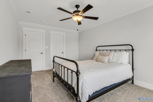 carpeted bedroom with ornamental molding and ceiling fan