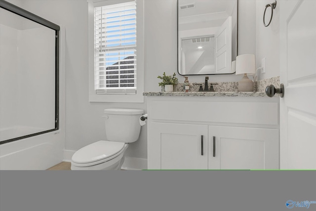 full bathroom featuring toilet, vanity, and bath / shower combo with glass door