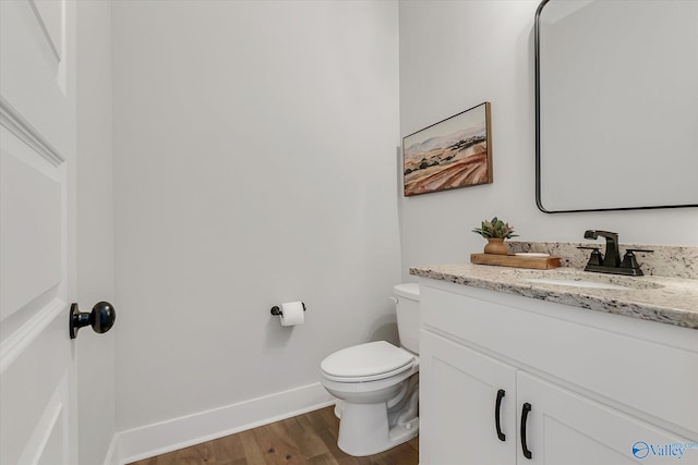 bathroom featuring vanity, wood-type flooring, and toilet