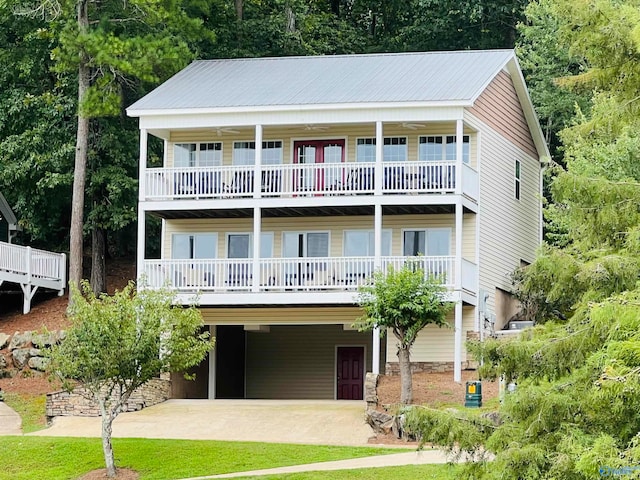 raised beach house featuring a balcony and a carport