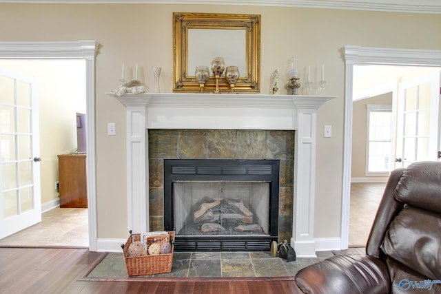 room details with wood finished floors, crown molding, a fireplace, and baseboards