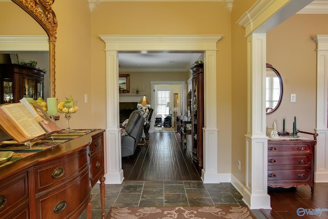 hallway with dark wood finished floors, crown molding, and baseboards
