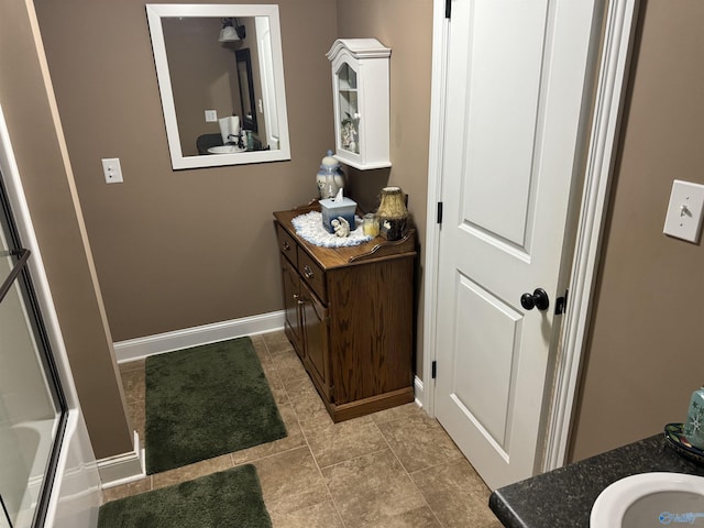 full bathroom with vanity and baseboards