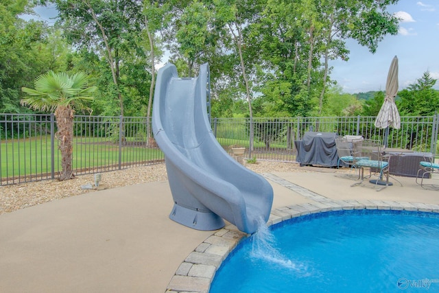 view of pool featuring a patio, area for grilling, fence, and a fenced in pool