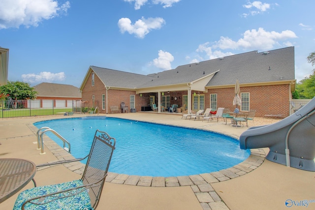 view of swimming pool featuring a fenced in pool, a patio, a water slide, and fence
