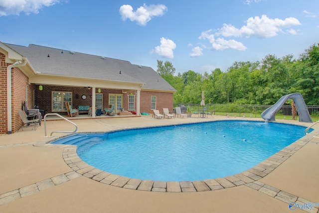 view of swimming pool featuring a fenced in pool, a patio, a water slide, and fence