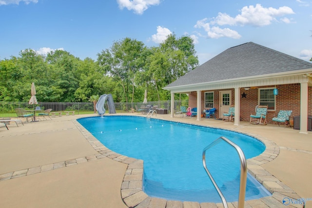 view of swimming pool with a fenced in pool, a patio, a water slide, and fence