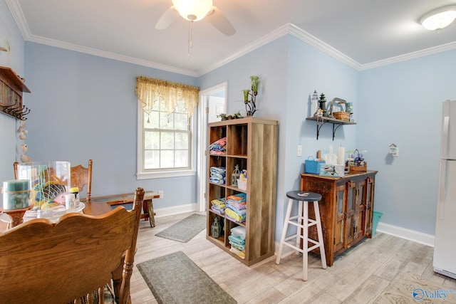 interior space with baseboards, ceiling fan, ornamental molding, and light wood finished floors