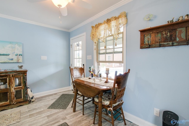 dining room with baseboards, crown molding, a ceiling fan, and wood finished floors