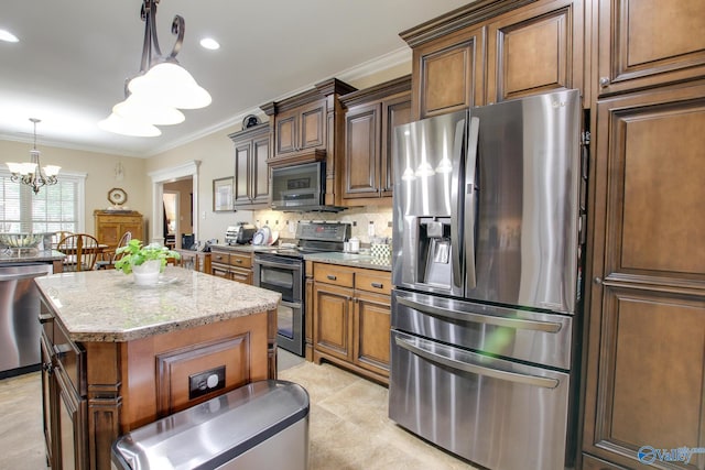 kitchen with backsplash, stainless steel appliances, a notable chandelier, and ornamental molding