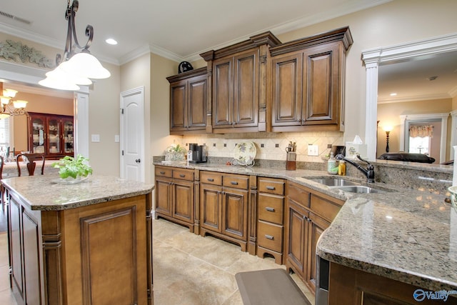 kitchen featuring ornamental molding, tasteful backsplash, visible vents, and a sink