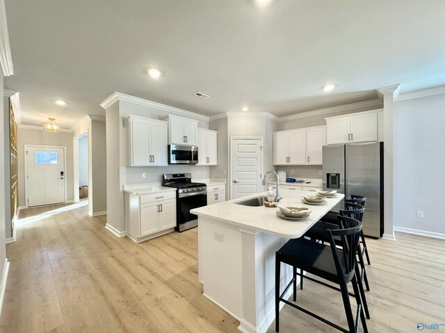 28570 Whitehall Ln, Madison, AL 35756 - kitchen featuring appliances with stainless steel finishes, a sink, ornamental molding, baseboards, and white cabinetry