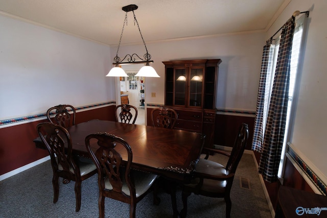 carpeted dining area featuring crown molding