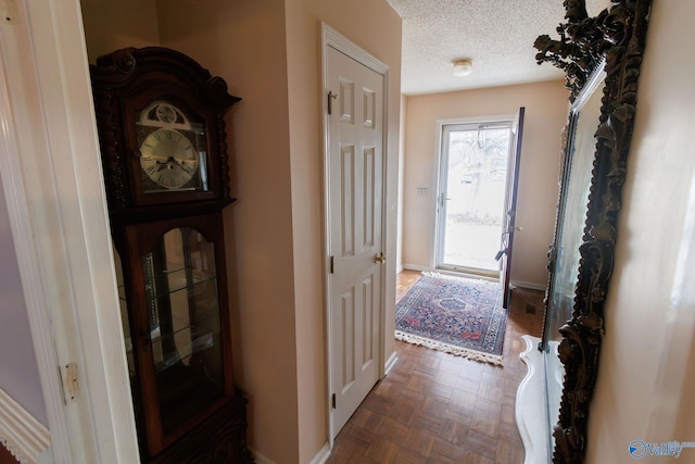 hall featuring dark parquet flooring and a textured ceiling