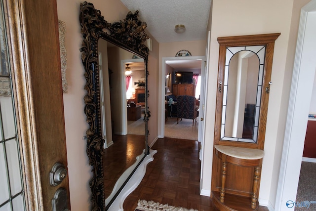 corridor with a textured ceiling and dark parquet floors