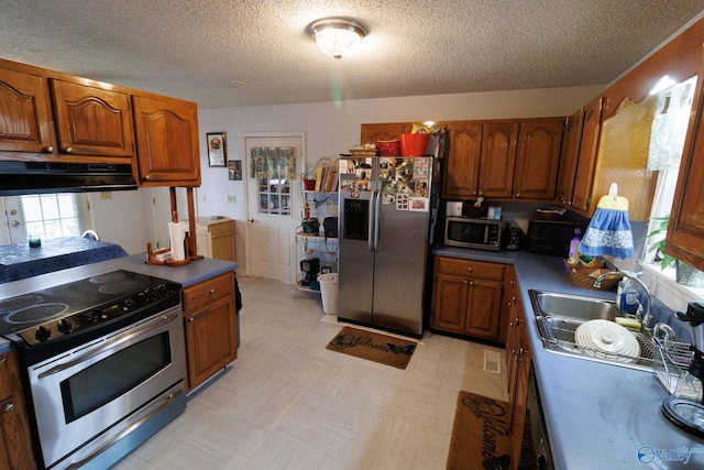 kitchen with stainless steel appliances, sink, and a textured ceiling