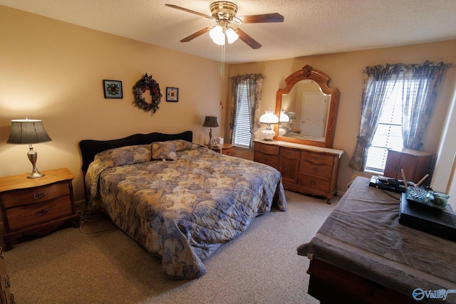 carpeted bedroom featuring ceiling fan and a textured ceiling