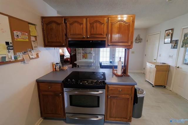 kitchen featuring ventilation hood, a textured ceiling, and stainless steel electric range oven