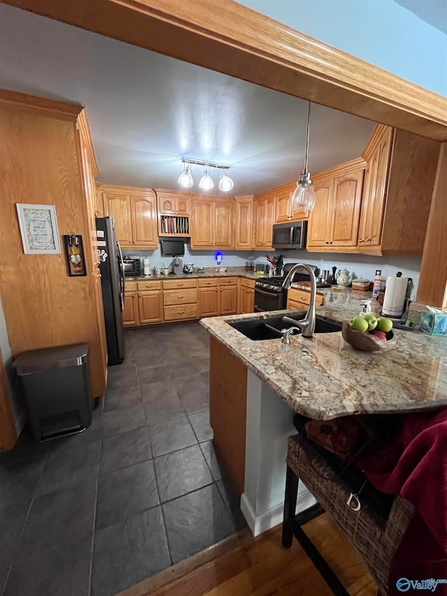 kitchen with pendant lighting, sink, light stone countertops, appliances with stainless steel finishes, and a kitchen bar