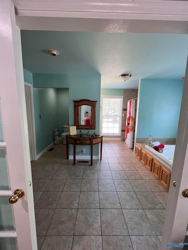 interior space featuring plus walk in shower, tile patterned floors, vanity, and toilet