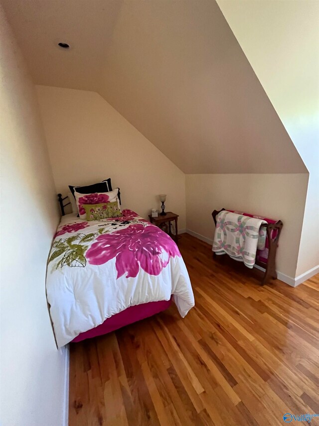 bedroom featuring lofted ceiling and hardwood / wood-style flooring