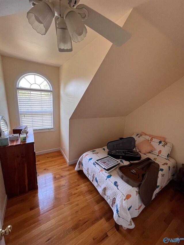 bedroom with light hardwood / wood-style floors, vaulted ceiling, and ceiling fan