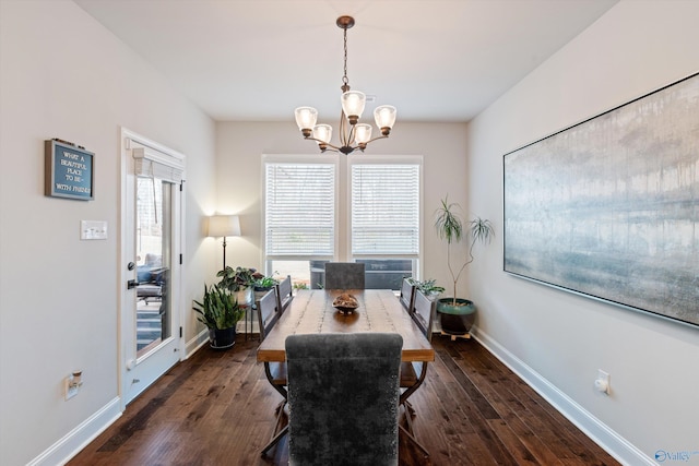 dining room with dark wood-type flooring and a chandelier