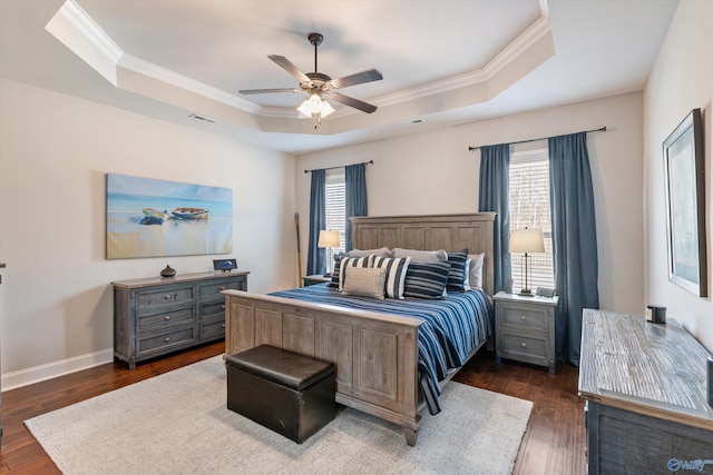 bedroom with a raised ceiling, crown molding, dark hardwood / wood-style floors, and ceiling fan