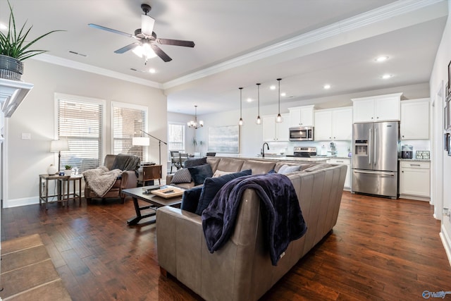 living room featuring sink, ornamental molding, dark hardwood / wood-style floors, and ceiling fan with notable chandelier