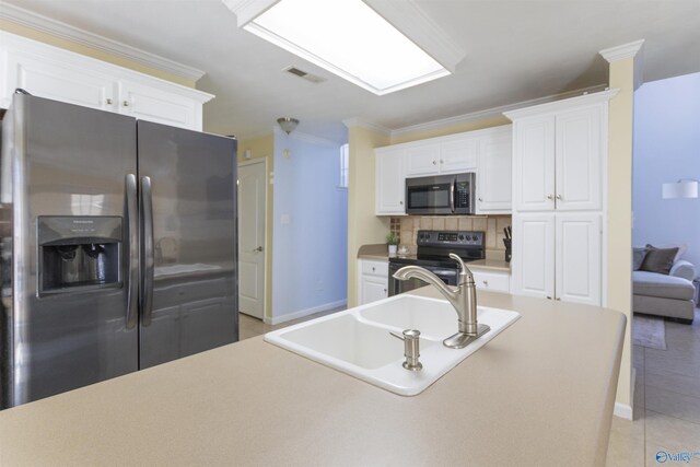 kitchen with a sink, tasteful backsplash, stainless steel appliances, crown molding, and light tile patterned floors