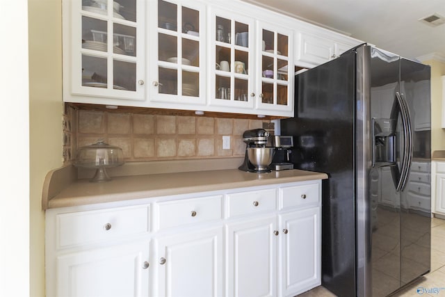 kitchen featuring glass insert cabinets, tasteful backsplash, stainless steel fridge with ice dispenser, and visible vents