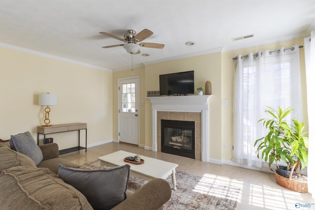 living area with a tiled fireplace, visible vents, tile patterned floors, and crown molding