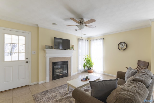 living room with tile patterned floors, baseboards, a tile fireplace, and ornamental molding